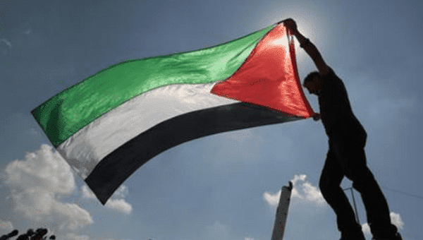 A Palestinian holds a flag during a protest near the Erez border crossing between Israel and northern Gaza Strip October 5, 2011