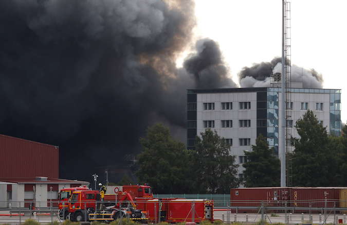 Dark smoke from a large fire that broke out at the factory of Lubrizol spreads over the town, in Rouen, France, September 26, 2019.