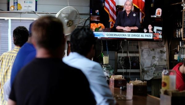 People watch television at a bar as Puerto Rico's Governor Wanda Vazquez Garced makes an address regarding the debt restructuring proposal filed in court by an oversight board, in San Juan, Puerto Rico, September 27, 2019.