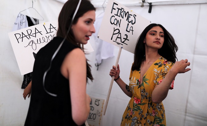 Model holds a sign reading ‘Stand with Peace’ at ‘PEACErella’, a fashion show organized by former rebels, in Bogota, Colombia, Sep. 18, 2019.