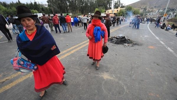 Indigenous women walking toward Quito and people closing the road in Cangagua, Pichincha, Ecuador, Oct. 5. 2019.