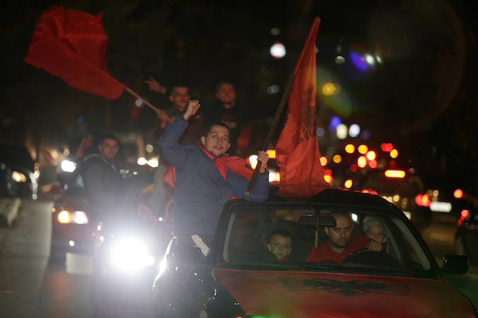 Supporters of the Self-Determination movement (Vetevendosje party) wave flags after preliminary results of the parliamentary election in Pristina, Kosovo, October 7, 2019.