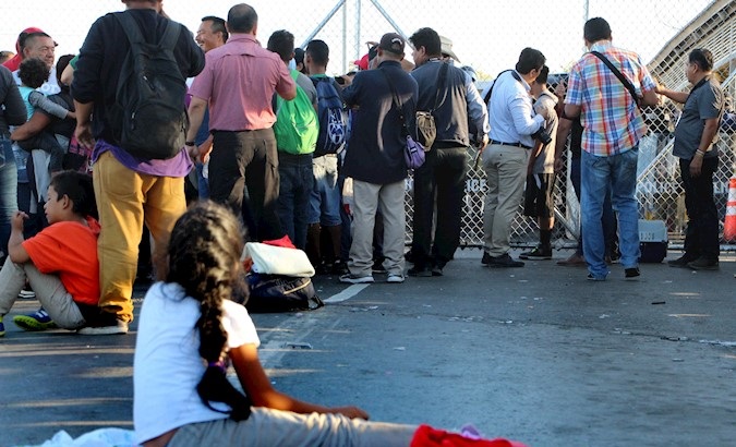 Migrants wait outside the Puente Nuevo border station in Matamoros, Mexico, Oct. 19, 2019.