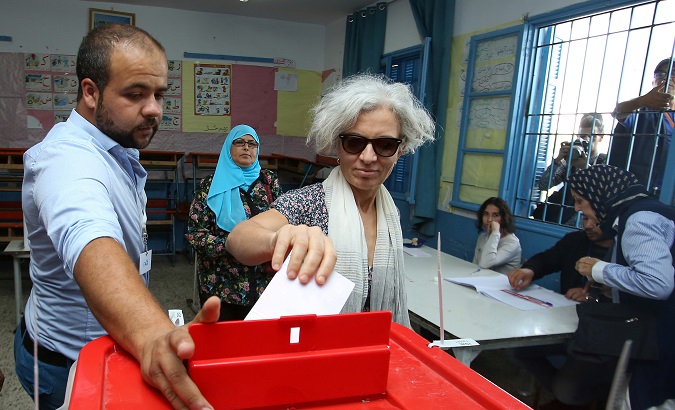 A woman casts her vote at a polling station during a second round runoff of a presidential election in Tunis, Tunisia October 13, 2019.