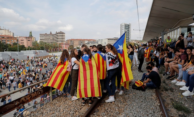 People carry and wear Esteladas (Catalan separatist flag) during a protest after a verdict in a trial over a banned independence referendum, in Girona, Spain, October 14, 2019.
