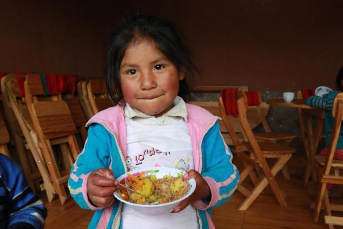 In 2019, a girl eats lunch in the Hanaq Chuquibamba community in Peru.