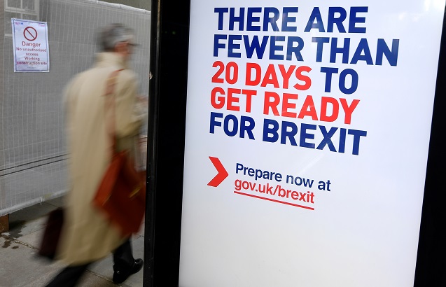 A man walks past an UK government Brexit information campaign poster at a bus stop in central London, Britain, October 15, 2019.