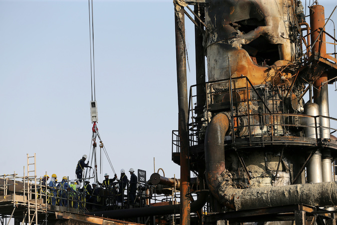 Workers are seen at the damaged site of Saudi Aramco oil facility in Abqaiq, Saudi Arabia, September 20, 2019.