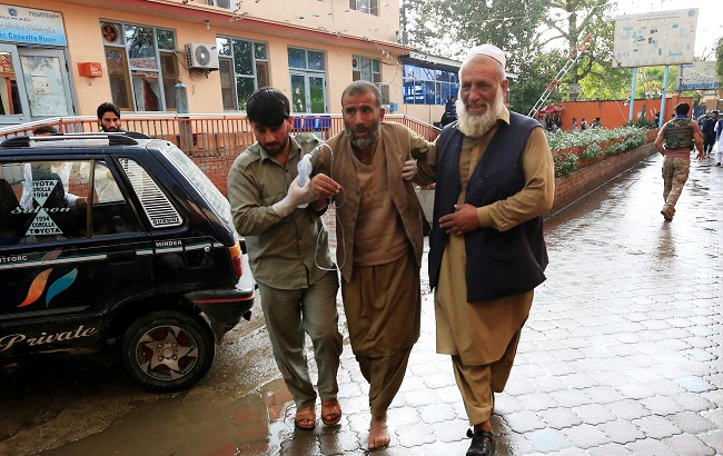 Men carry an injured person to a hospital after a bomb blast at a mosque, in Jalalabad, Afghanistan October 18, 2019.
