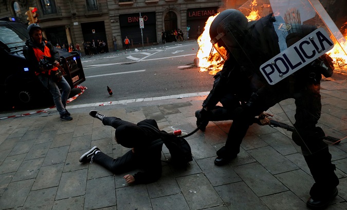 Police officer keeps hitting a young man who fell to the floor in Barcelona, Catalonia, Spain, Oct. 18, 2019.