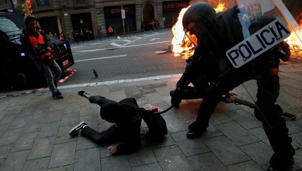 Police officer keeps hitting a young man who fell to the floor in Barcelona, Catalonia, Spain, Oct. 18, 2019.