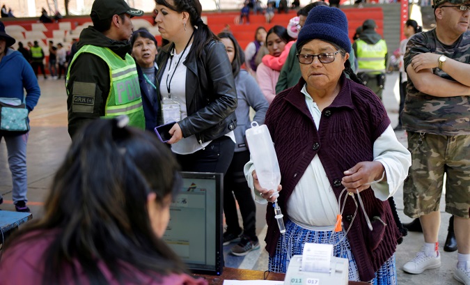 An election official checks a voter's information at a polling station during the presidential election in La Paz, Bolivia Oct. 20, 2019.
