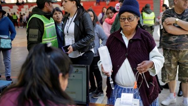 An election official checks a voter's information at a polling station during the presidential election in La Paz, Bolivia Oct. 20, 2019.