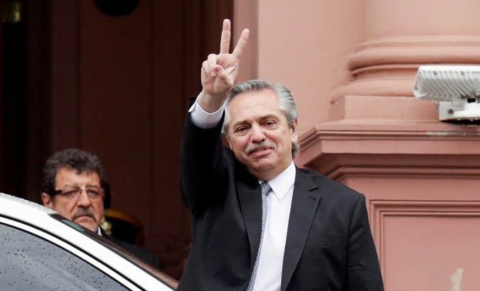 President-elect Alberto Fernandez flashes a V sign as he leaves after a meeting with Argentina's President Mauricio Macri at the presidential palace Casa Rosada.