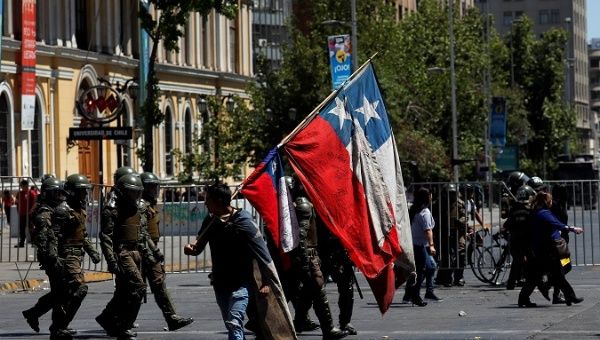 A demonstrator holds a Chilean flag during an anti-government protests in Santiago, Chile October 28, 2019. 
