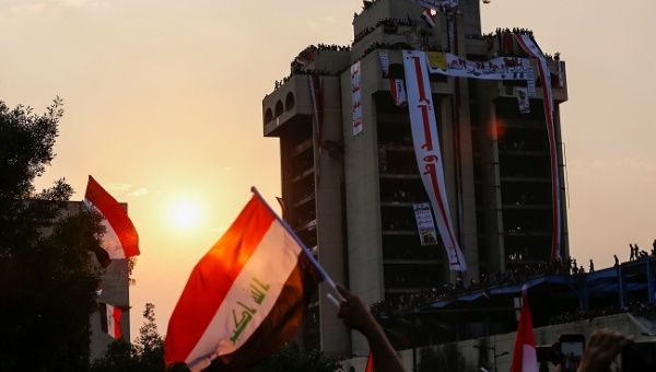 Demonstrators are seen on a building with Iraqi flags during a protest over corruption, lack of jobs, and poor services, in Baghdad, Iraq October 29, 2019.