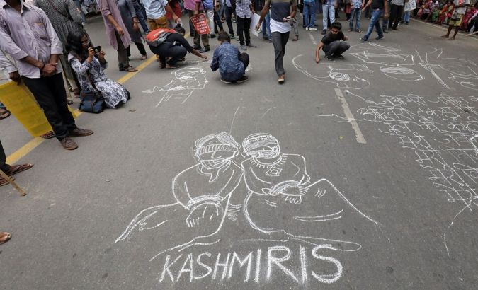 People draw and write messages on a road during a protest against the scrapping of the special constitutional status for Kashmir by the government, in New Delhi, India, August 7, 2019.