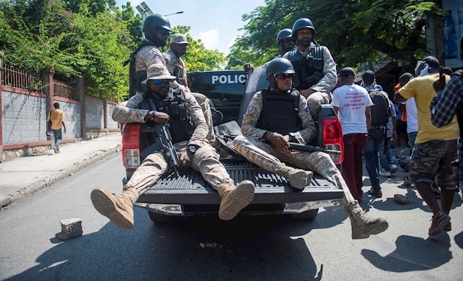 Policemen patrol the streets armed with assault weapons during protests in Port-au-Prince, Haiti, Oct. 31, 2019.
