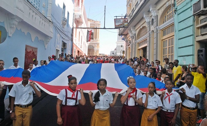 Students hold their country's flag in Santiago de Cuba, Cuba, Nov. 4, 2019.