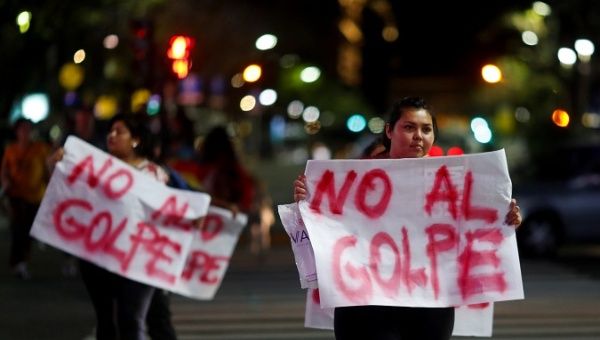 Bolivian residents in Argentina hold placards that reads 