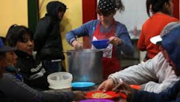 A volonteer serves a stew in a charity kitchen in Buenos Aires, Oct. 4, 2019.