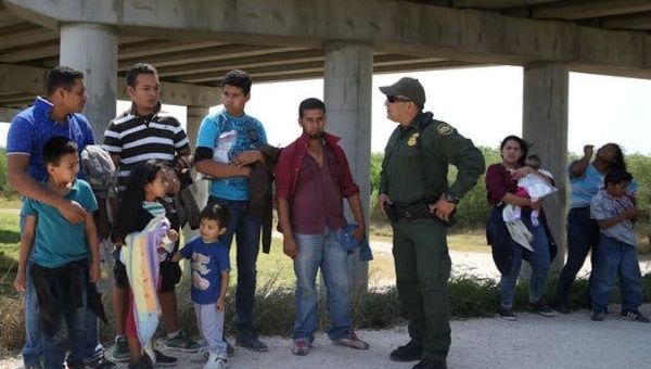 A Border Patrol agent talking with migrants who illegally crossed the border from Mexico into the United States near McAllen, Tex.