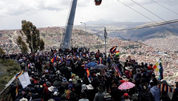 People march next to coffins of people they say were killed during recent clashes with security forces in Senkata, as they take part in a protest, in La Paz, Bolivia November 21, 2019. The placard reads: 