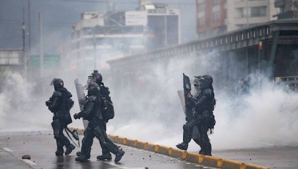 Riot police officers walk amid tear gas during a protest in Bogota, Colombia, November 21, 2019.