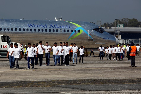Guatemalan migrants walk on the tarmac after being deported from U.S., at La Aurora International airport in Guatemala City.