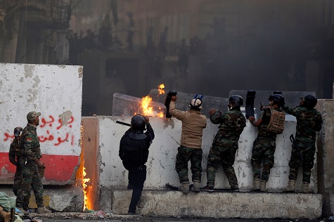 Iraqi security forces clash with demonstrators during ongoing anti-government protests, in Baghdad.