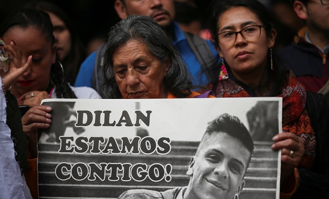 A woman holding a placard in honour of Dilan Cruz in Bogota, Colombia. The placard reads, 
