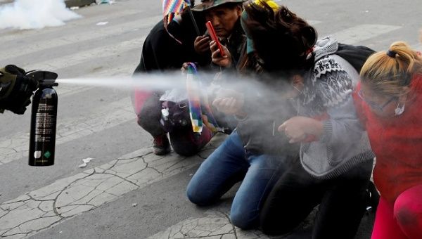 Demonstrators are pepper sprayed by a member of the security forces during clashes between supporters of former Bolivian President Evo Morales and the security forces, in La Paz, Bolivia November 15, 2019.