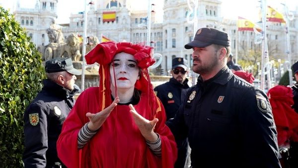 Extinction Rebellion activist is escorted by police officers after staging a protest at Cibeles Fountain in Madrid, Spain, Dec. 3, 2019.