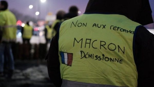 Workers gathering for protest at dawn on Saturday. The yellow vest's sign says, “No to reforms. Step out Macron.” France, Dec. 7, 2019.
