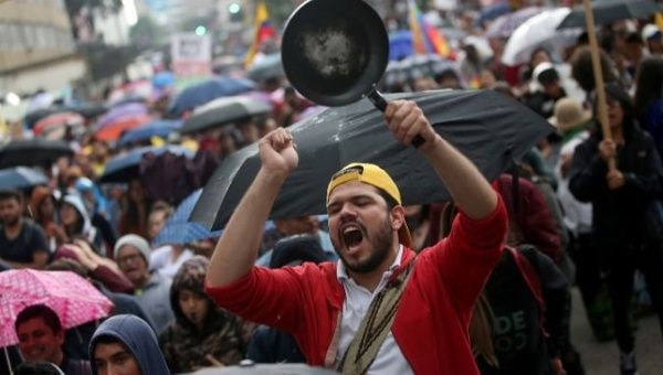 A man bangs a pan during a protest march combined with concerts as a national strike continues in Bogota, Colombia December 8, 2019.