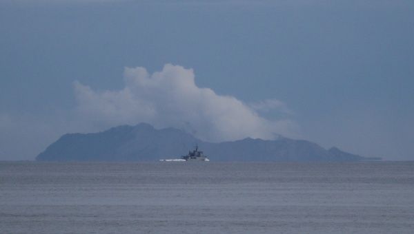 A military ship is seen in front of Whakaari, also known as White Island volcano, seen from Ohope beach in Whakatane, New Zealand, December 12, 2019.