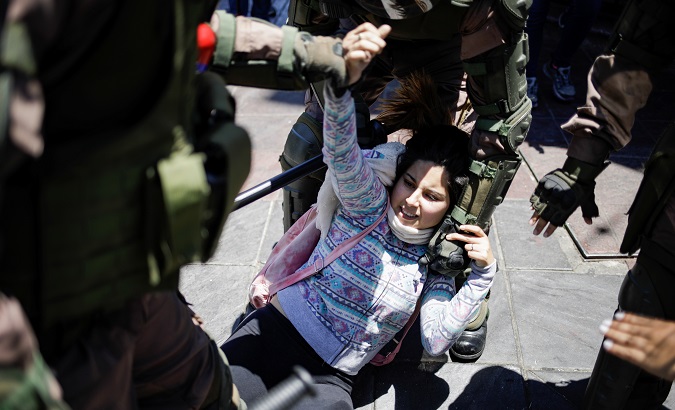 A woman is detained by military police members in Valparaiso, Chile Dec. 12, 2019.