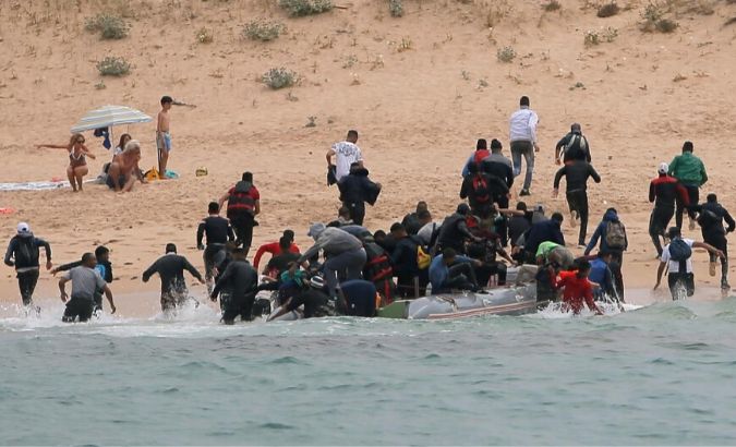 Migrants disembark from a dinghy at Del Canuelo beach after they crossed the Strait of Gibraltar sailing from the coast of Morocco, in Tarifa, southern Spain.