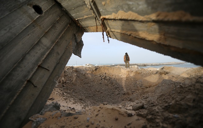 A Palestinian militant checks the site of an Israeli air strike in the southern Gaza Strip December 26, 2019.