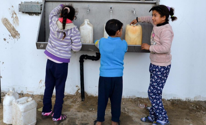 Palestinian children fill buckets with drinking water from China-funded water desalination plants in al-Naser village in the Gaza Strip's southern border town of Rafah, on Jan. 8, 2020.