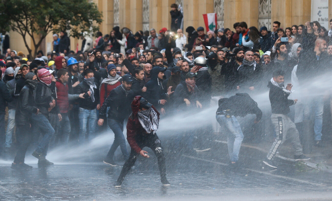 Demonstrators are hit by water canon during a protest against a ruling elite accused of steering Lebanon towards economic crisis in Beirut, Lebanon January 18, 2020.
