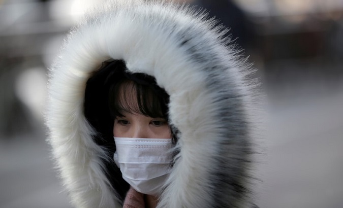 A woman wearing a mask walks along a street in Beijing, China, Jan. 21, 2020.