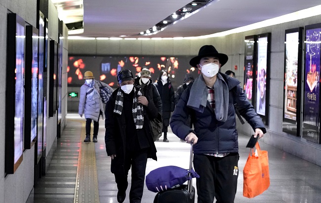 People wearing masks walk through an underground passage to the subway in Beijing, China January 21, 2020.