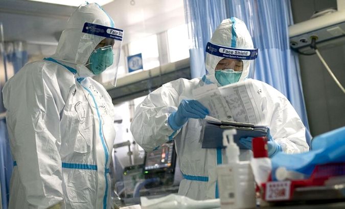 A medical worker checks diagnosis record of a patient with his colleague in Zhongnan Hospital of Wuhan University in Wuhan, central China's Hubei Province, Jan. 24, 2020.