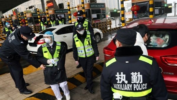 Police officers wearing masks check the boot of a car for smuggled wild animals following the outbreak of a new coronavirus, at an expressway toll station on the eve of the Chinese Lunar New Year celebrations, in Xianning, a city bordering Wuhan to the north, Hubei province, China January 24, 2020.