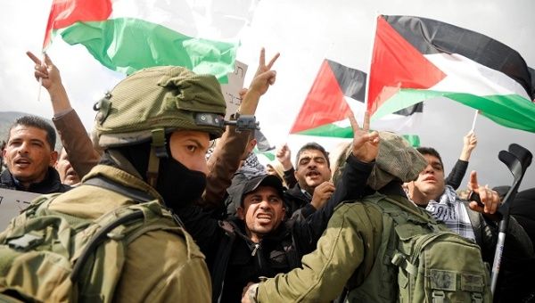 Palestinian demonstrators gesture in front of Israeli forces during a protest against the U.S. president Donald TrumpÕs Middle East peace plan, in Jordan Valley in the Israeli-occupied West Bank January 29, 2020. 