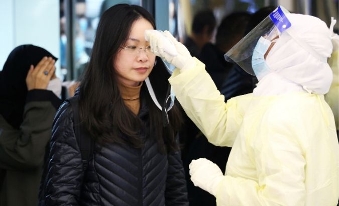 Passengers from China wearing masks to prevent a new coronavirus are checked by Saudi Health Ministry employees upon their arrival at King Khalid International Airport, in Riyadh, Saudi Arabia Jan. 29, 2020