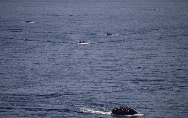 Refugees and migrants are seen onboard eight dinghies as they cross a part of the Aegean Sea from the Turkish coast to reach the Greek island of Lesbos, October 4, 2015.