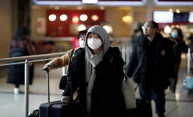 Tourists from an Air China flight from Beijing wear protective masks as they arrive at Charles de Gaulle airport in Paris, France, January 26, 2020.
