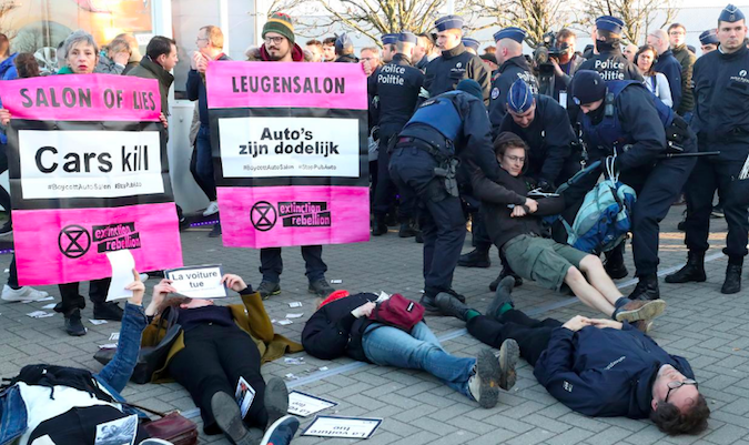 Demonstrators lay in a street during a protest of the climate action group Extinction Rebellion at Brussels Motor Show in Brussels, Belgium Jan. 18, 2020.